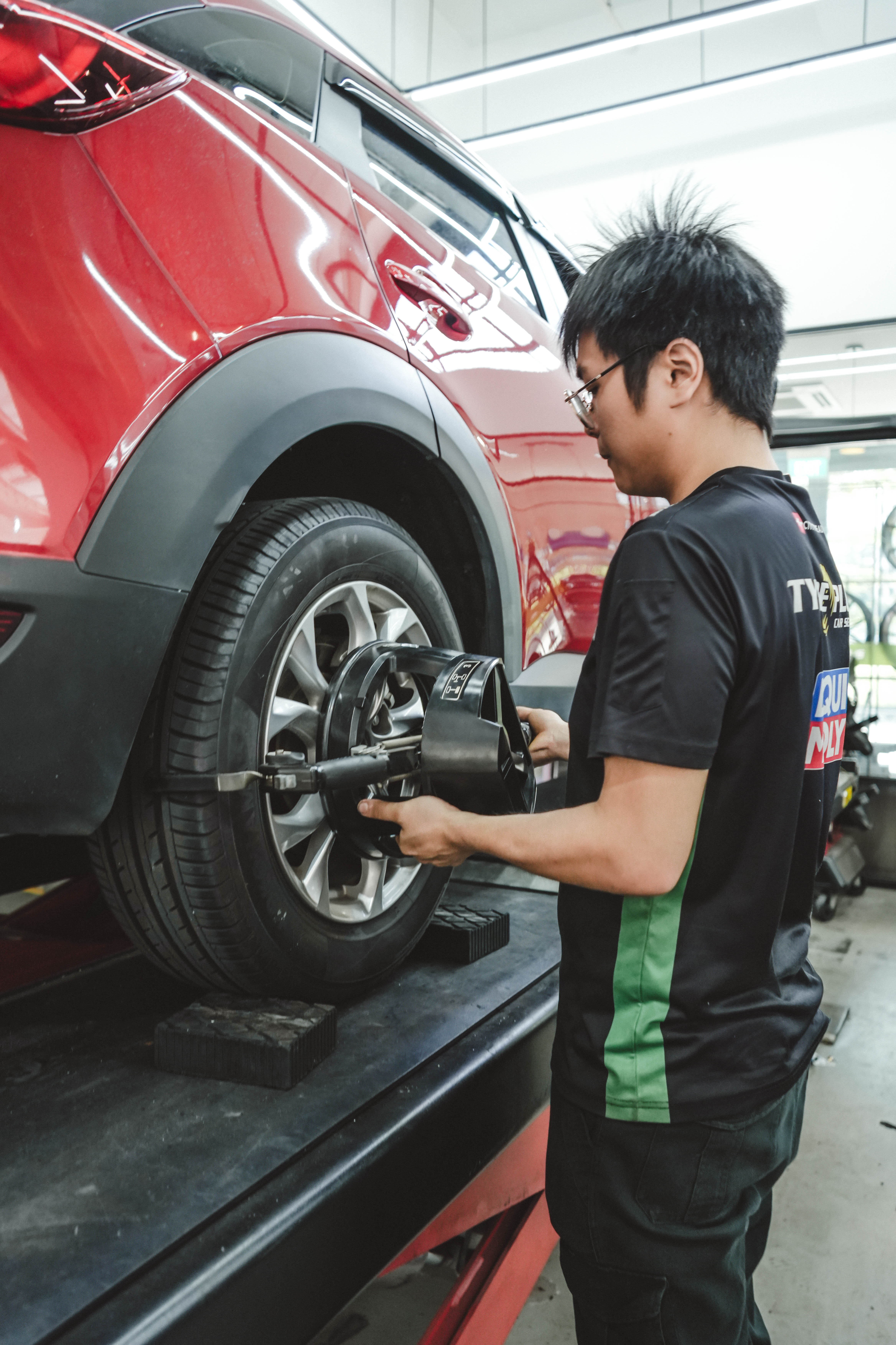 Tyre replacement Jurong service bay with car on hydraulic lift at TYREPLUS Jurong workshop